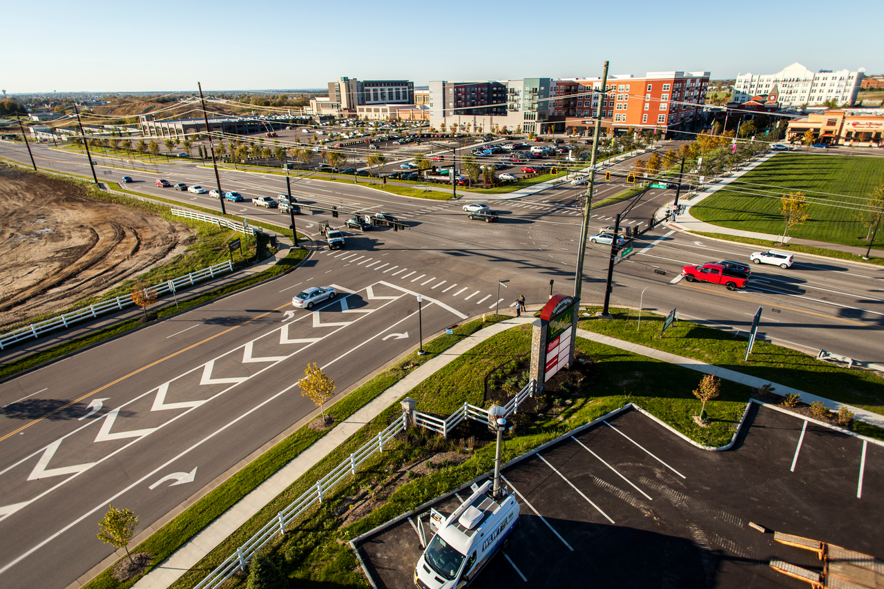 Aerial view of an urban intersection with cars and surrounding buildings.