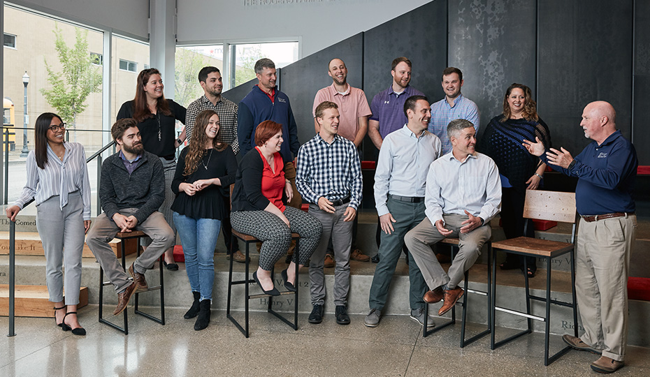 Office group sitting and standing on stairs, engaged in conversation.