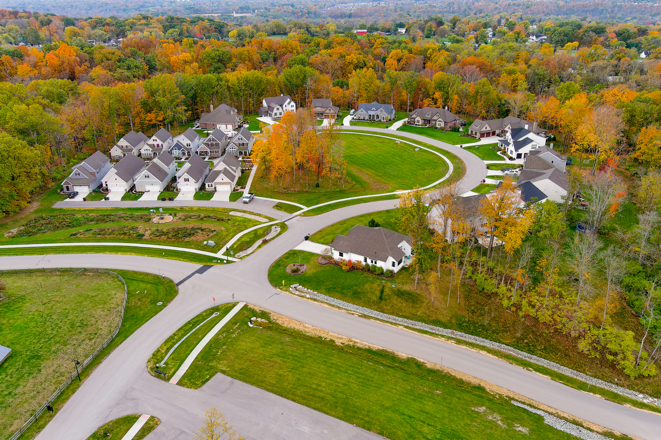 Aerial view of a suburban neighborhood with colorful autumn trees.