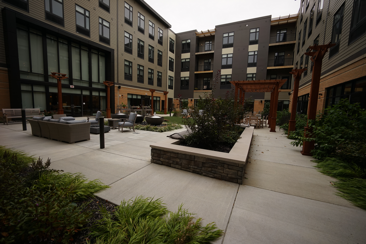 Cozy courtyard with patio furniture and surrounding apartment buildings.