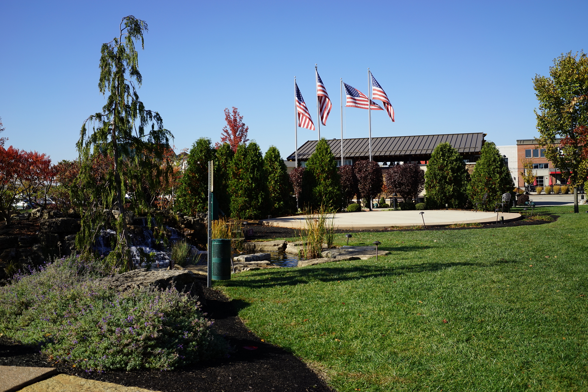 Flags outside a building with green lawns and trees.