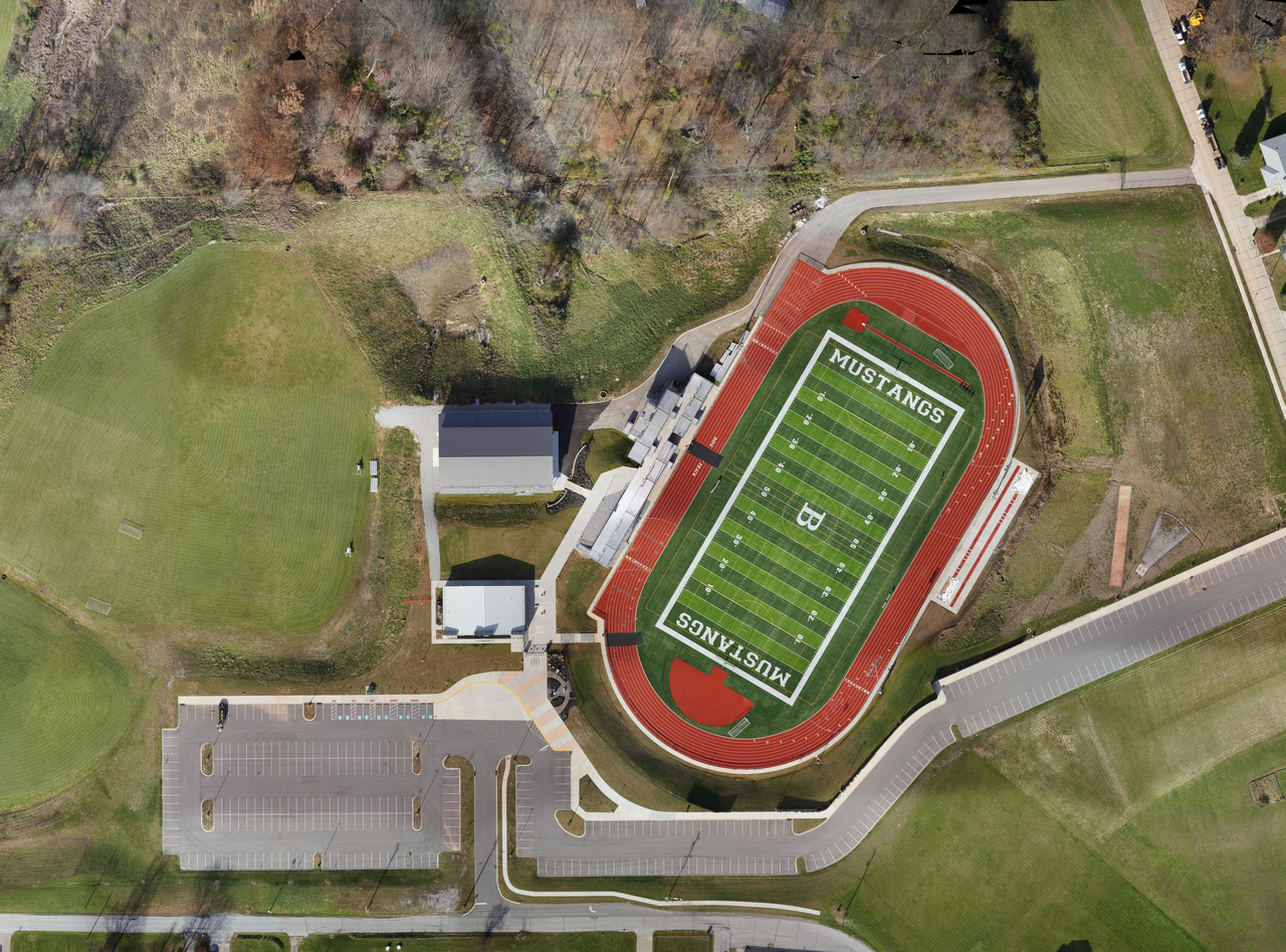 Aerial view of a football field with a red running track.