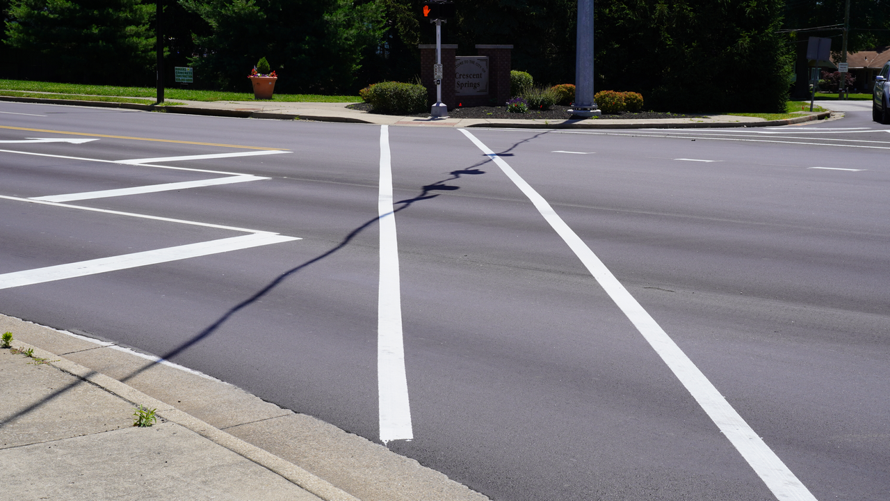 Intersection with fresh white lane markings and traffic light.
