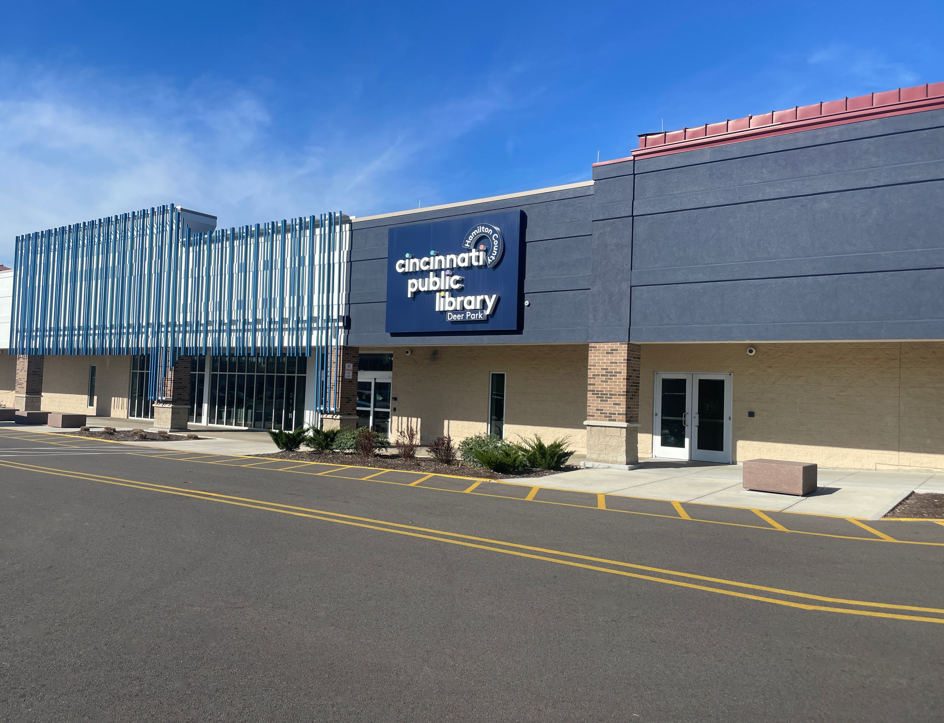 Modern library building with blue accents and a clear sky.