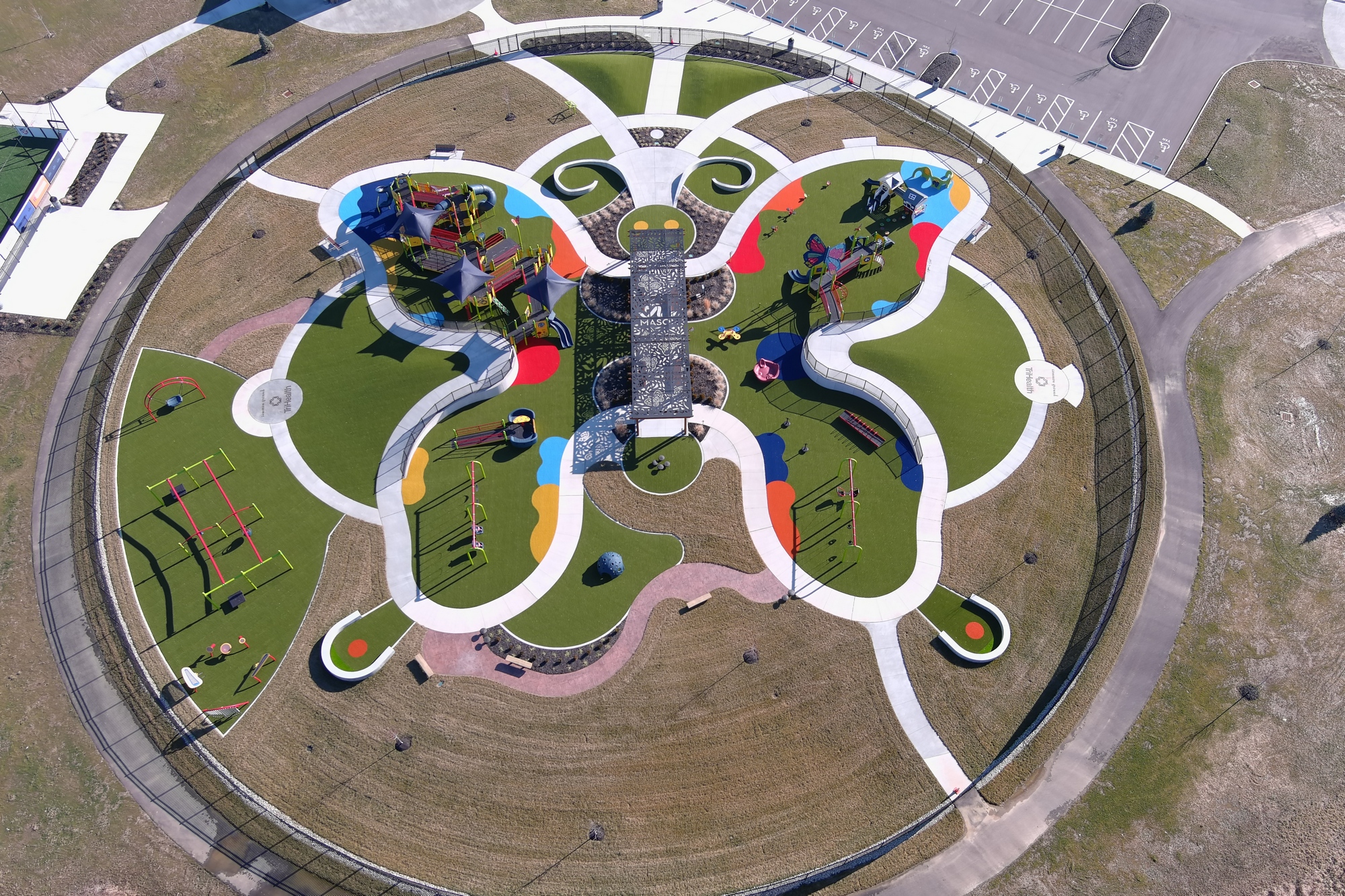 Butterfly-shaped playground with colorful pathways, aerial view.