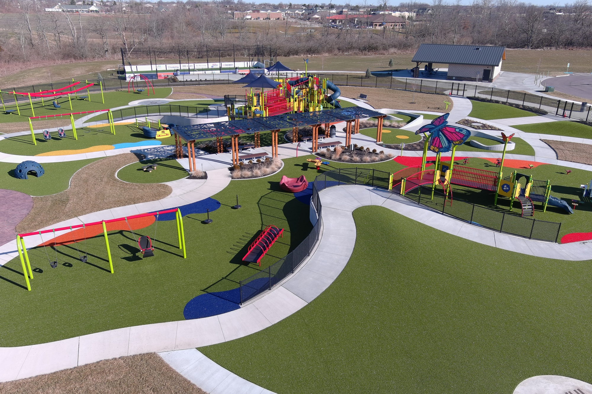 Playground with colorful slides, swings, and paths on a bright, sunny day.
