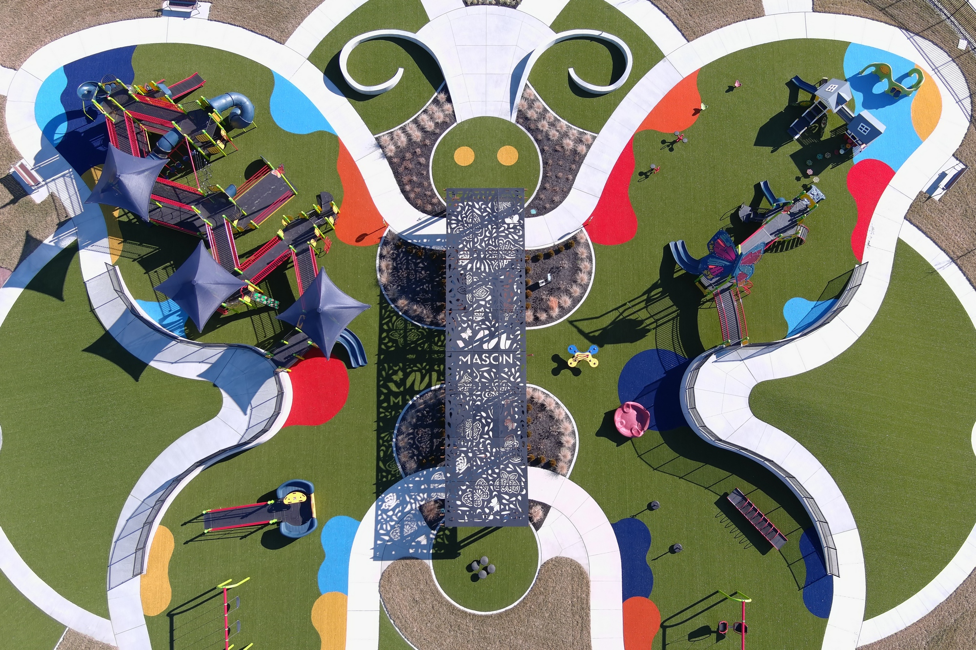 Butterfly-shaped playground with colorful equipment and pathways.