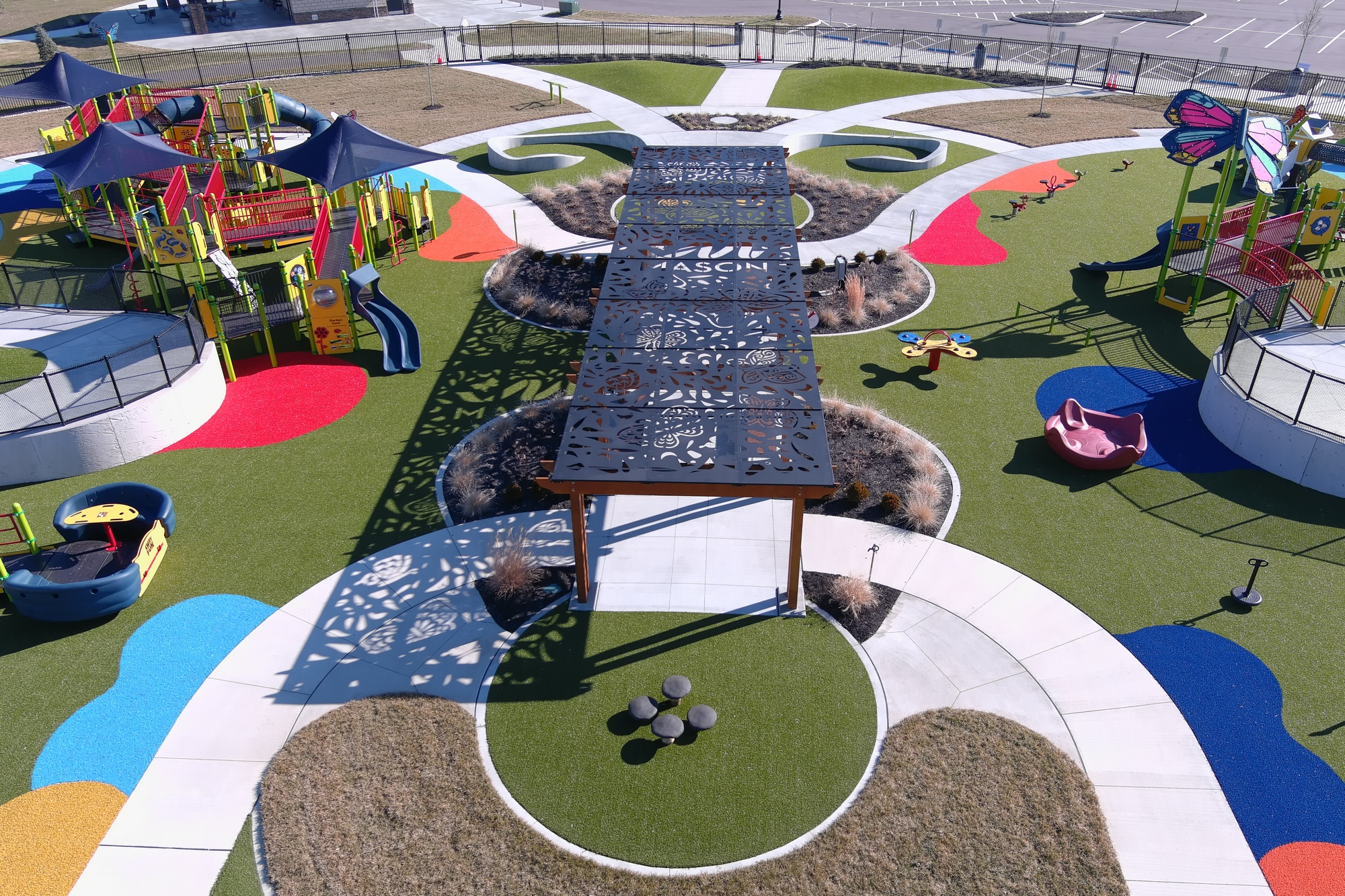 Colorful playground with slides, shade structures, and circular pathways.