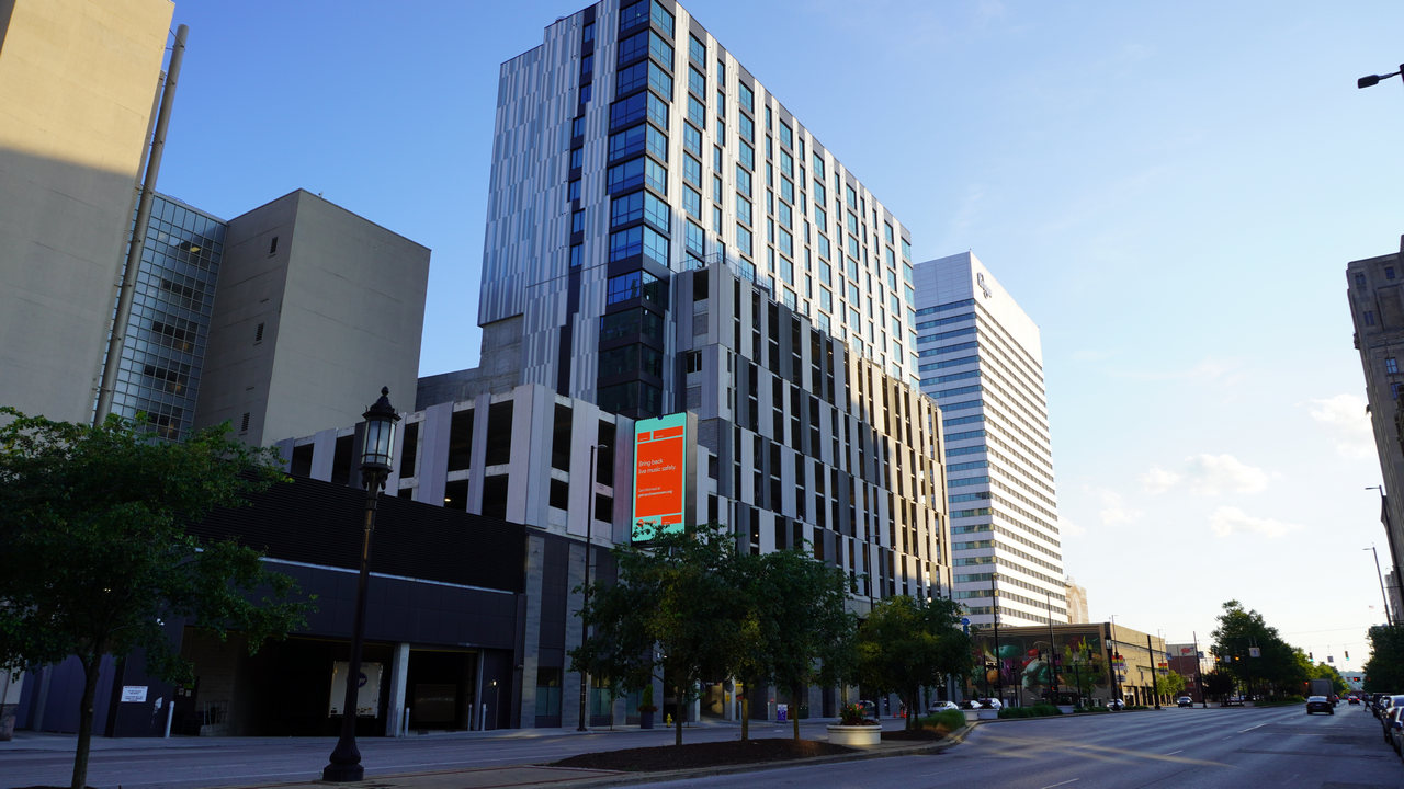 Downtown street with modern high-rise buildings and trees.