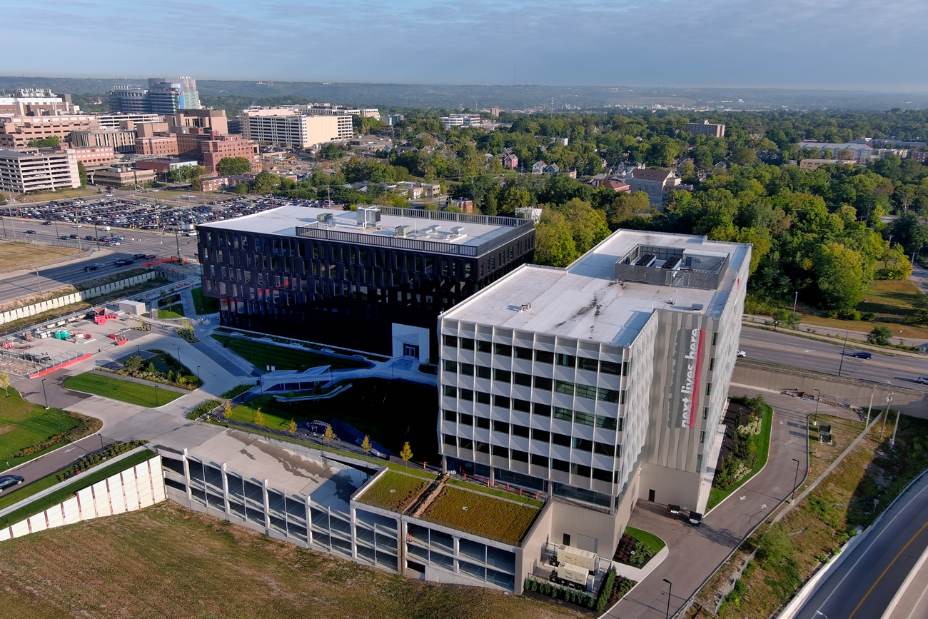 Aerial view of modern office buildings surrounded by trees and roads.