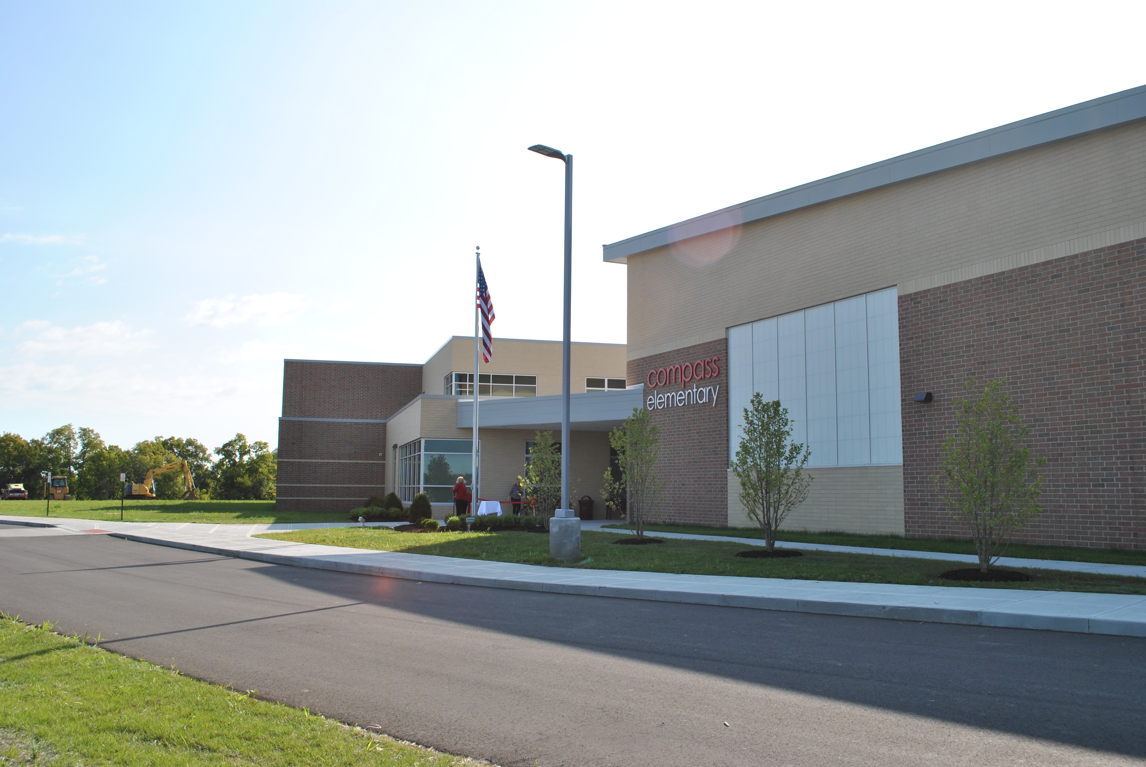 School building with American flag, clear sky.