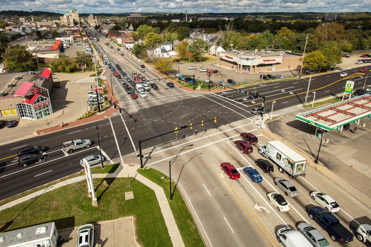 Aerial view of a busy city intersection with cars and buildings.