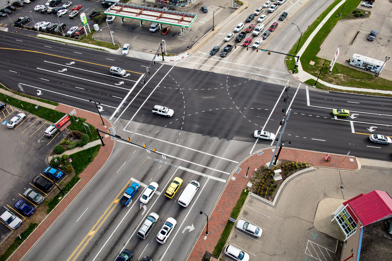 Aerial view of a busy crossroads with cars and traffic lights.