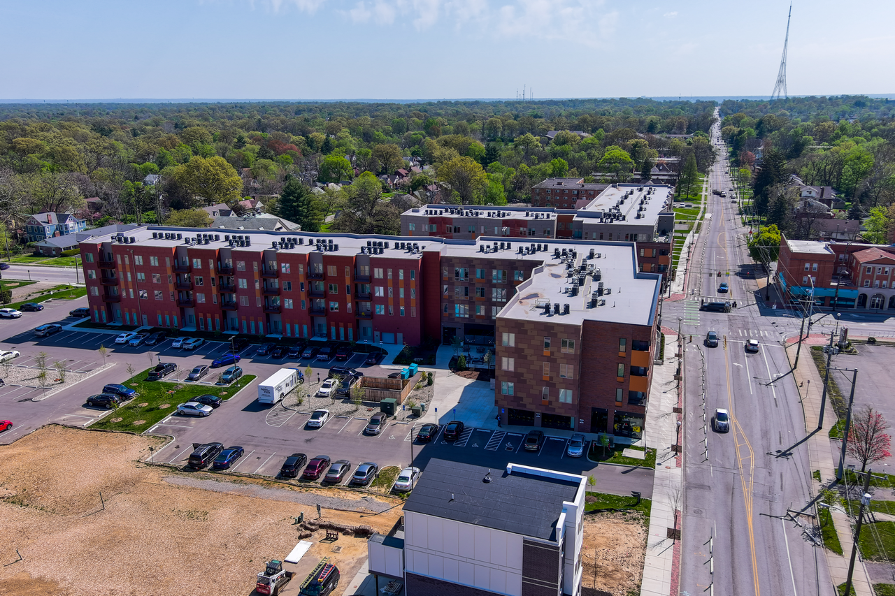 Aerial view of a red brick apartment complex and surrounding area.