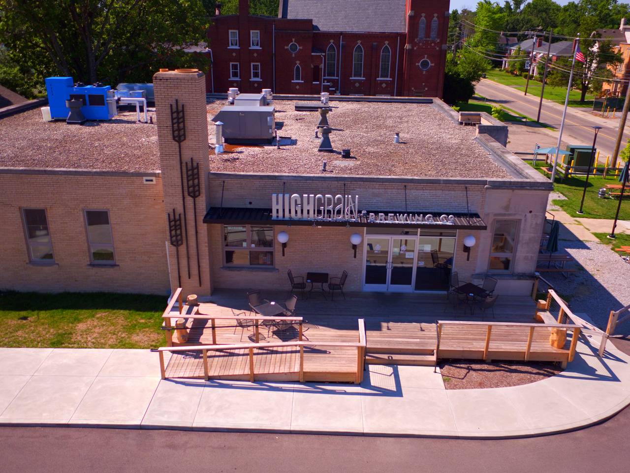 Large brick building with outdoor patio and street view.