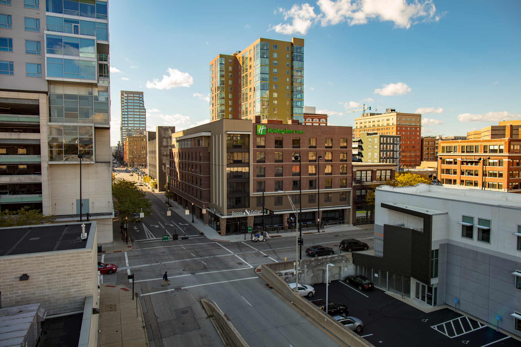 Urban street intersection with tall buildings under a clear blue sky.