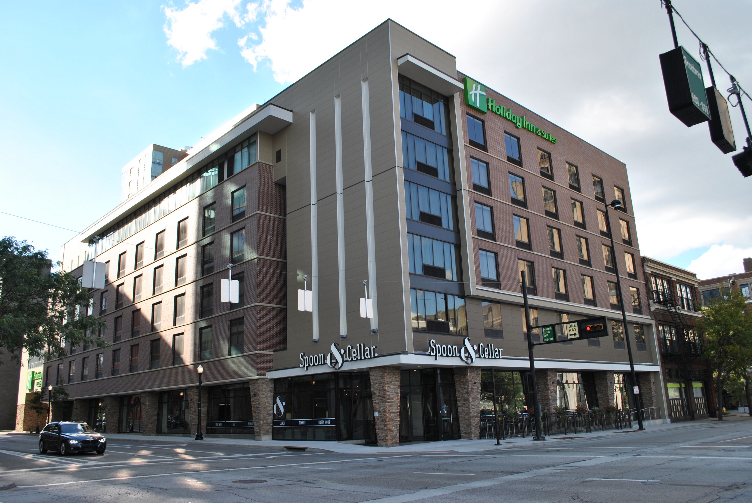 Modern hotel building on a city corner with clear skies above.