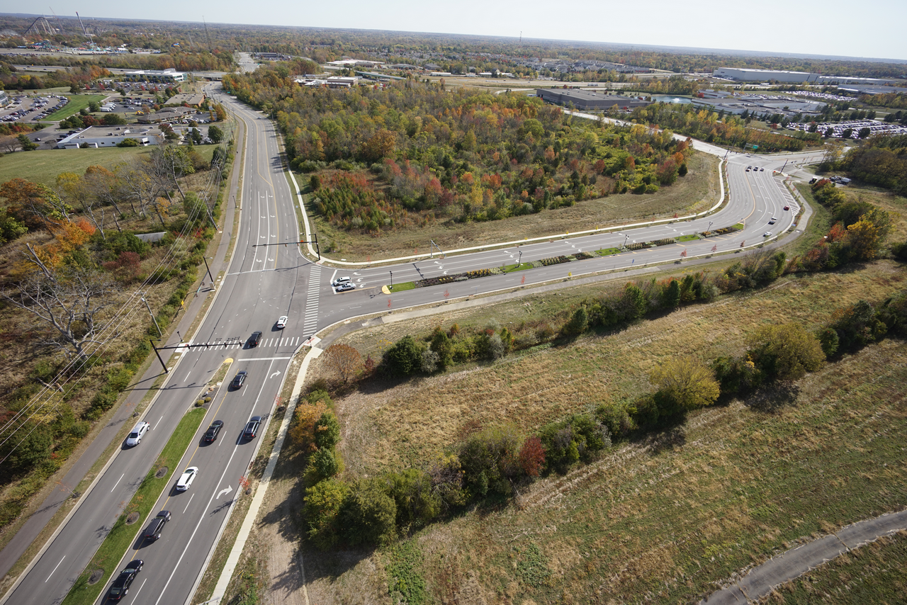 Aerial view of a road intersection surrounded by autumn trees and open land.