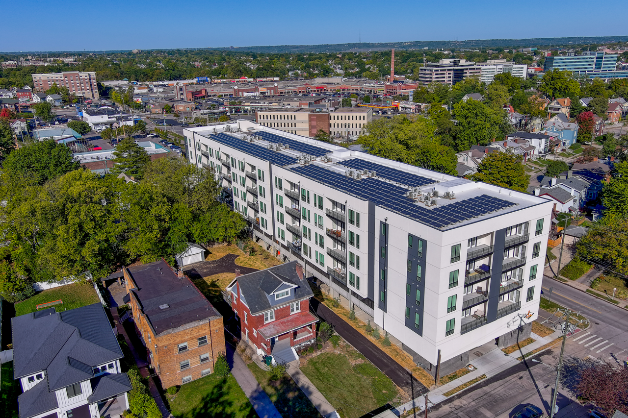 Aerial view of a modern white building and surrounding neighborhood.