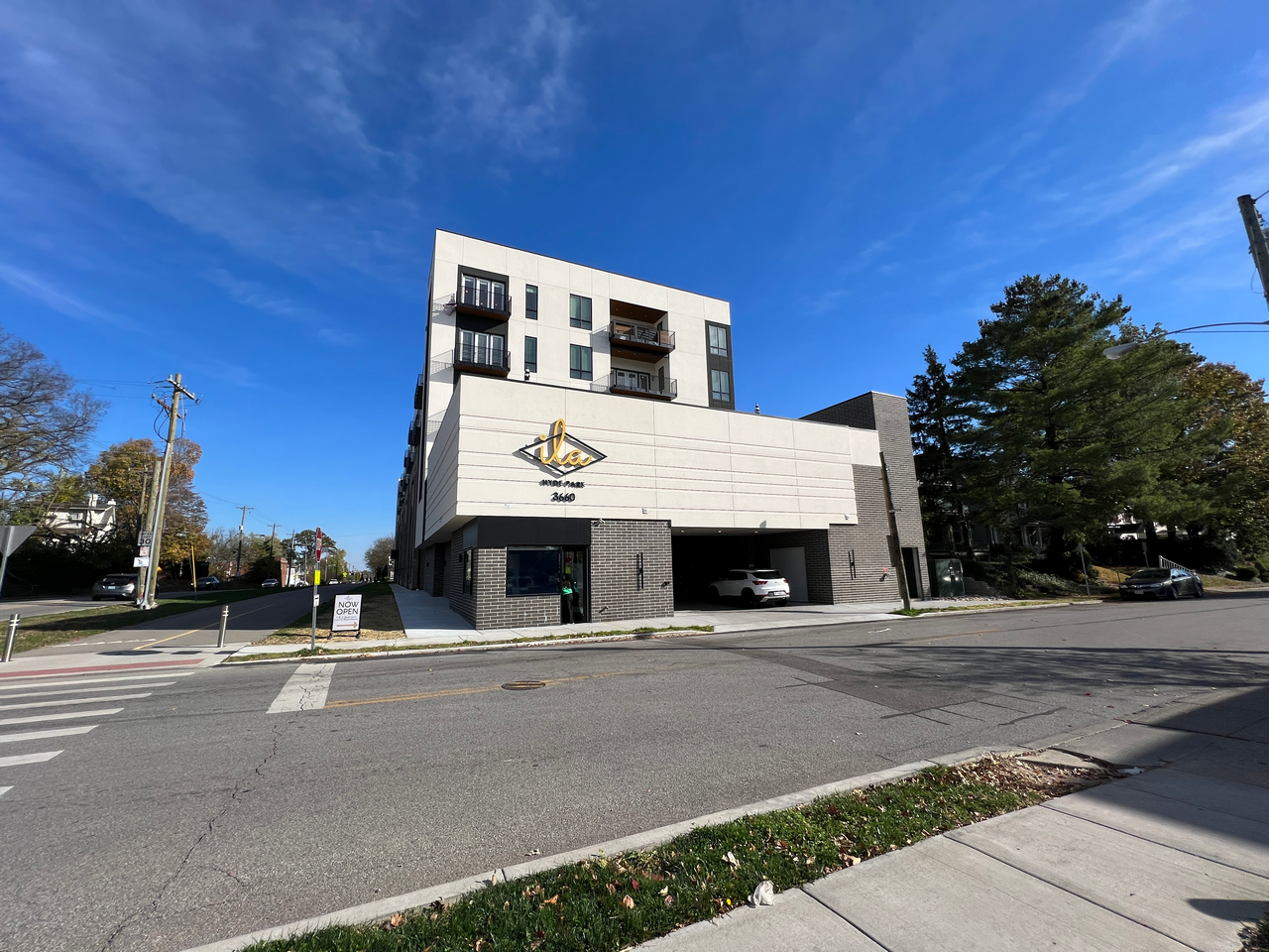 Modern building on a street corner under a clear blue sky.
