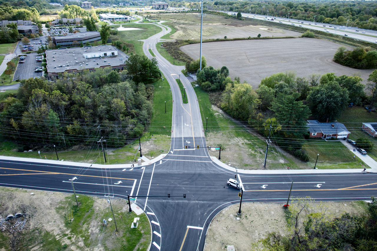 Aerial view of a rural intersection with roads, trees, and a field.