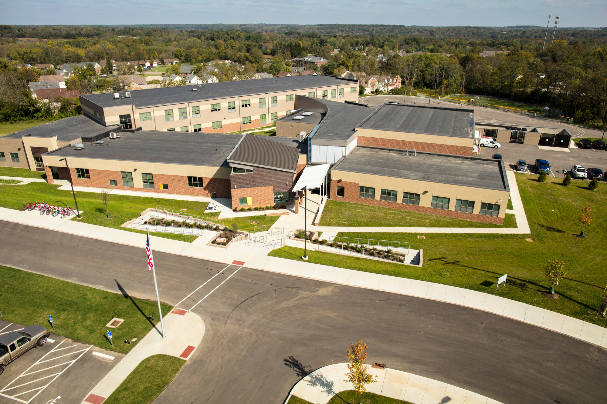 Aerial view of a modern, sprawling school complex with green surroundings.