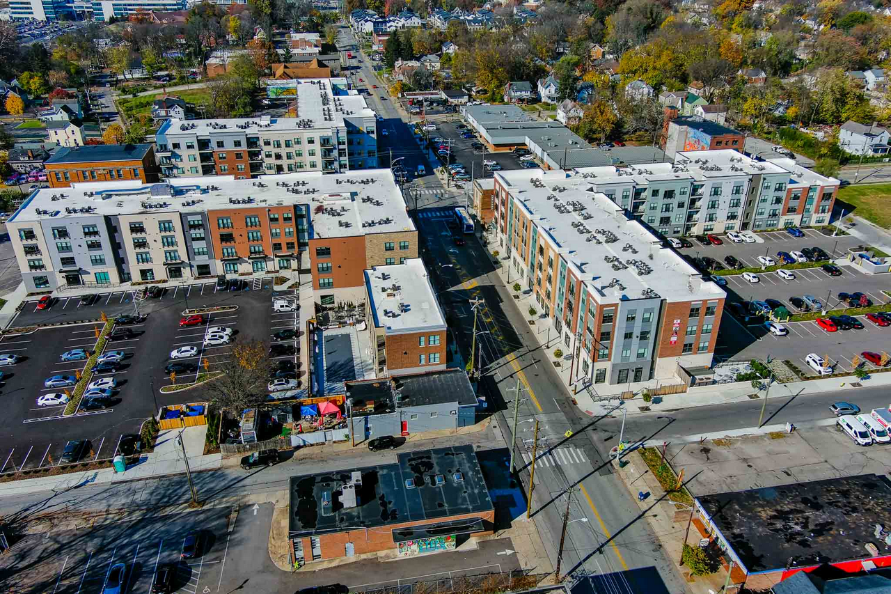 Aerial view of urban buildings and parking lots in a cityscape setting.
