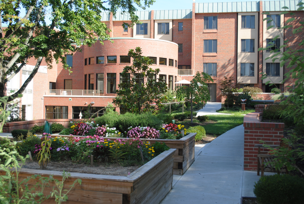 Brick building with garden and pathway in foreground.