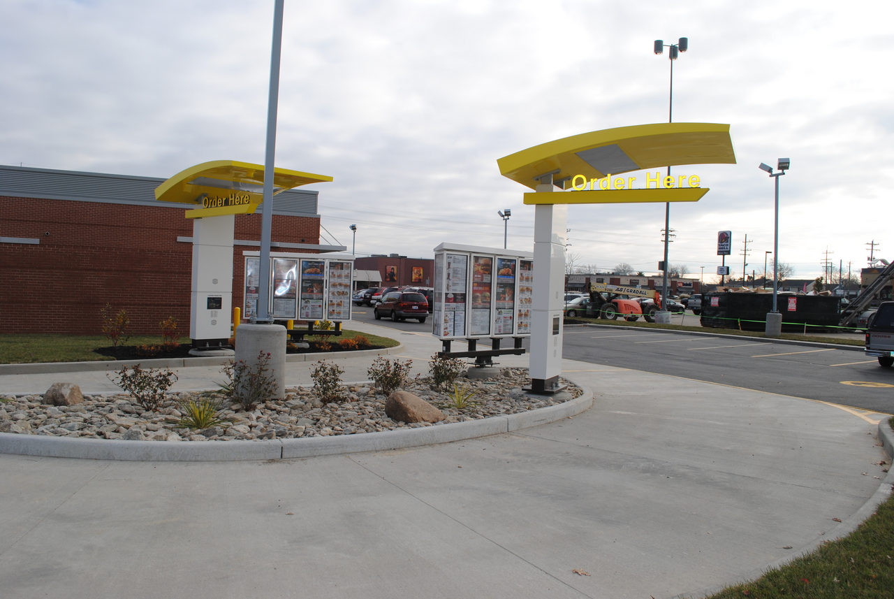 Drive-thru lane with yellow arches at a fast-food restaurant.