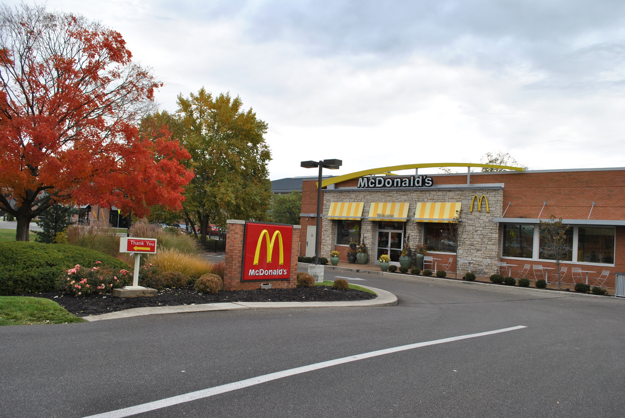 McDonald's exterior with autumn trees and cloudy sky.