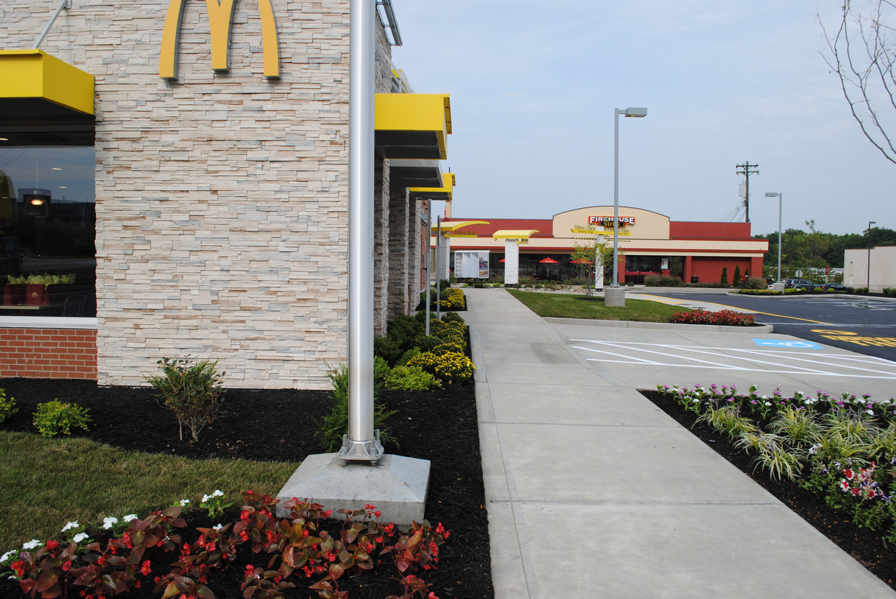 McDonald's building exterior with a sidewalk and landscaped garden.