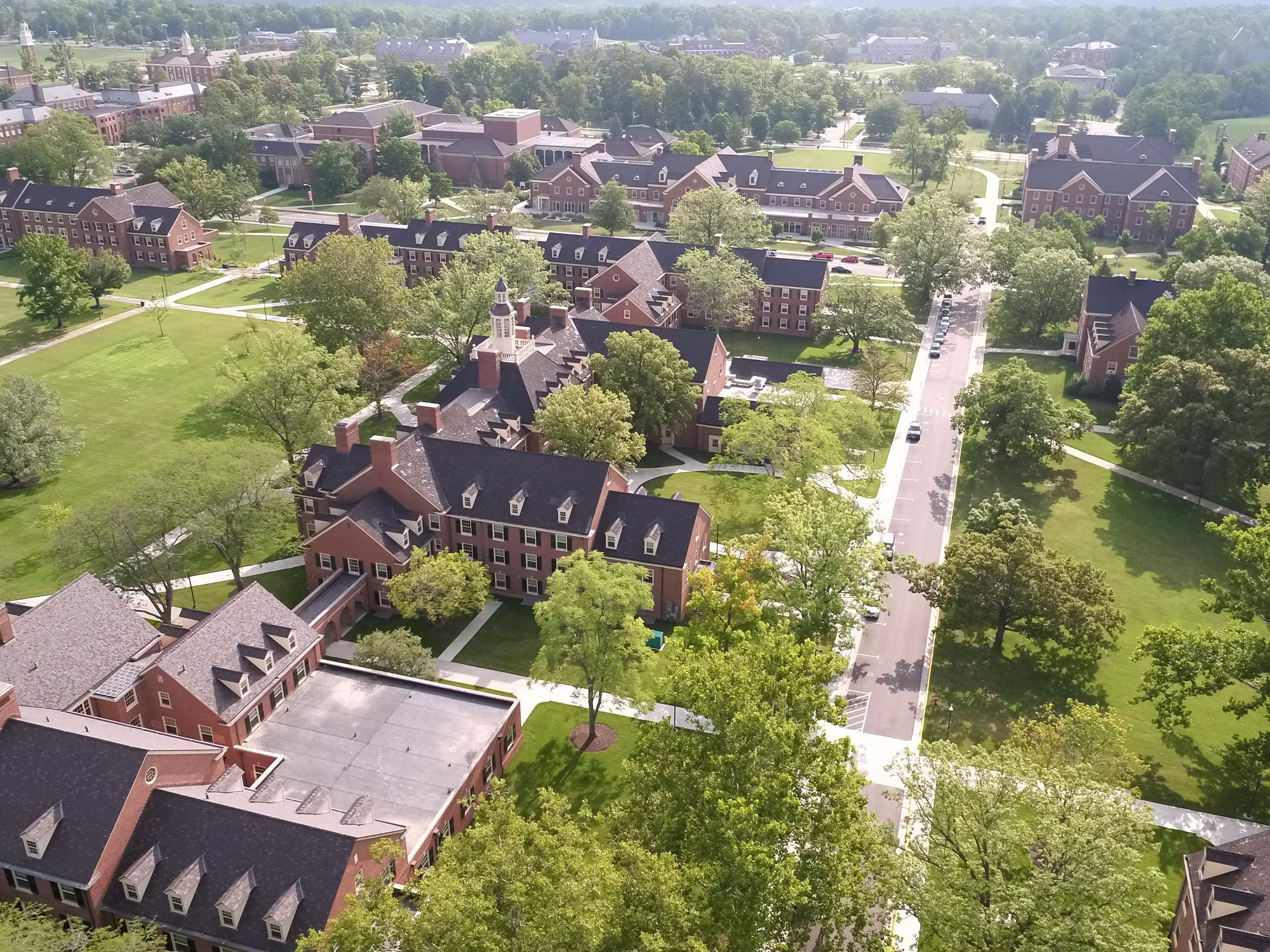 Aerial view of a leafy college campus with brick buildings and paths.
