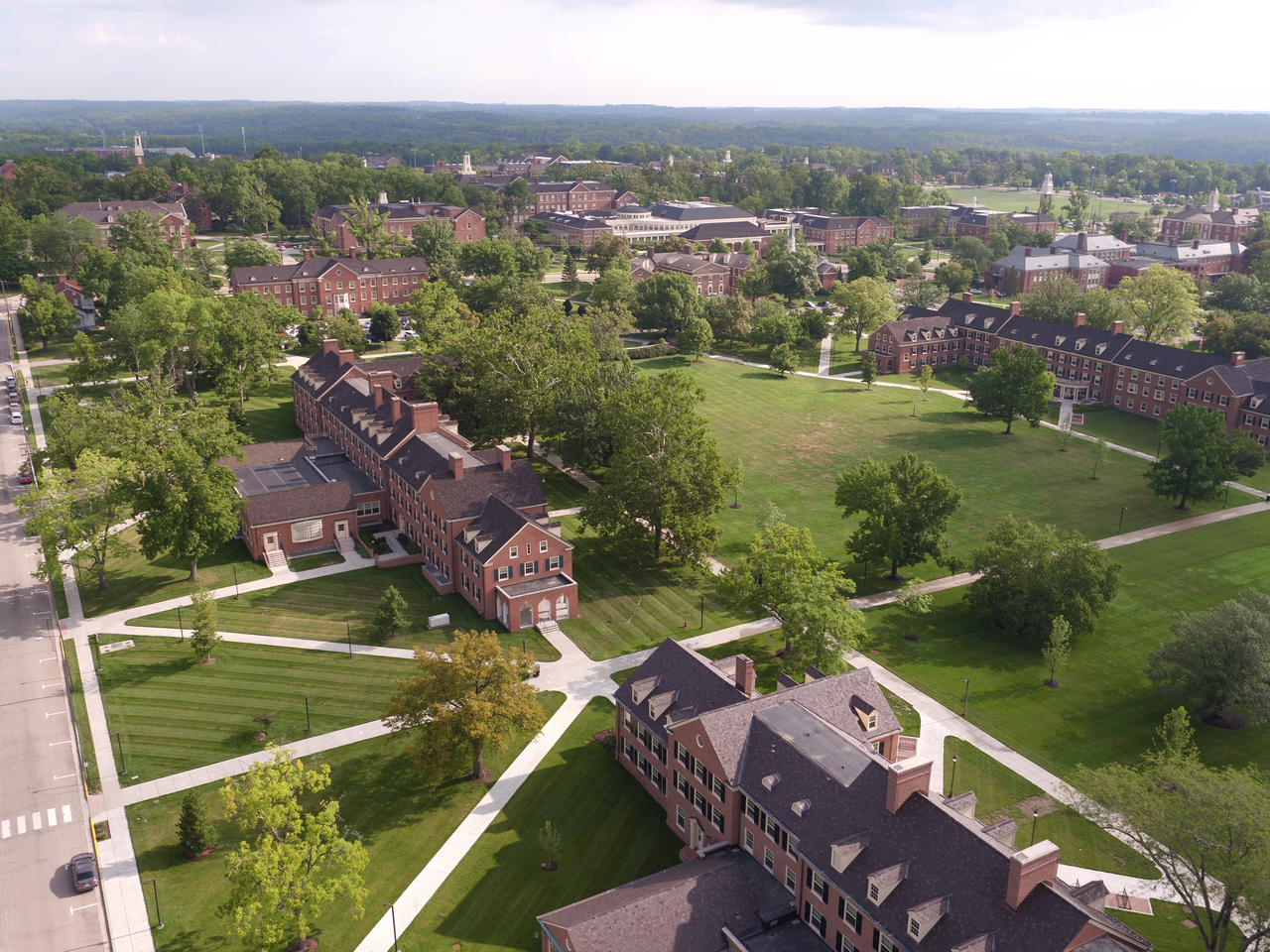 Aerial view of a college campus with red-brick buildings and green lawns.