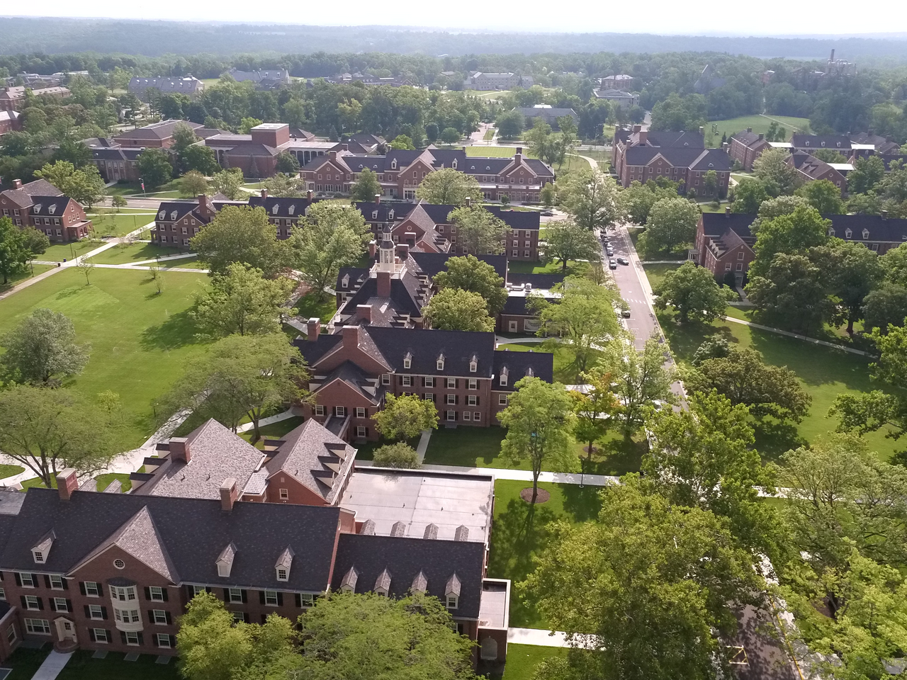 Aerial view of a leafy campus with brick buildings and paths.