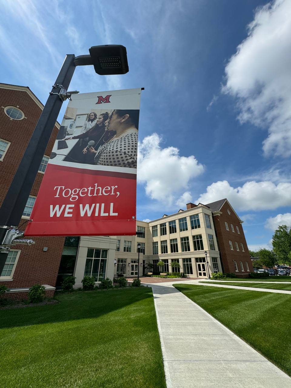 Campus buildings with a red banner on a sunny day.