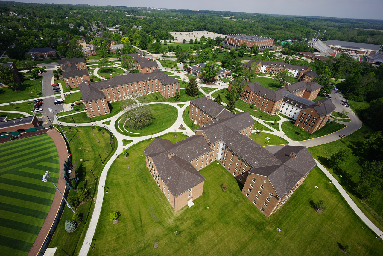 Aerial view of a university campus with brick buildings and green lawns.