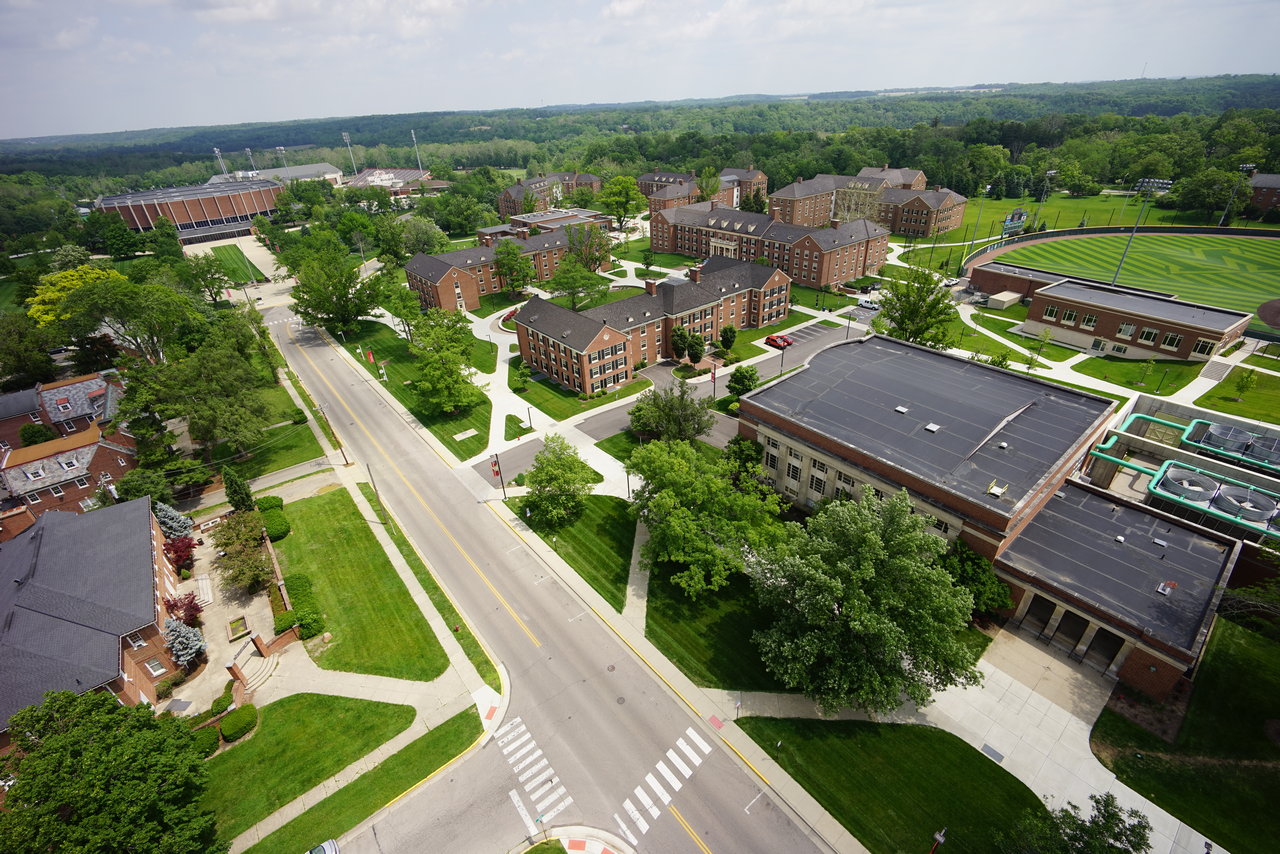 Aerial view of a campus with roads, trees, and buildings.
