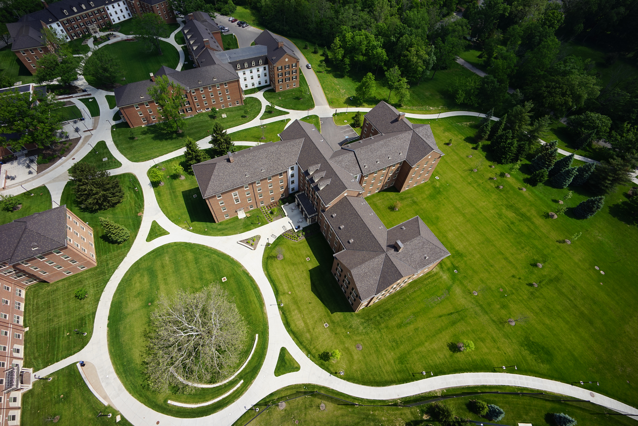 Aerial view of campus buildings and green lawns with winding paths.