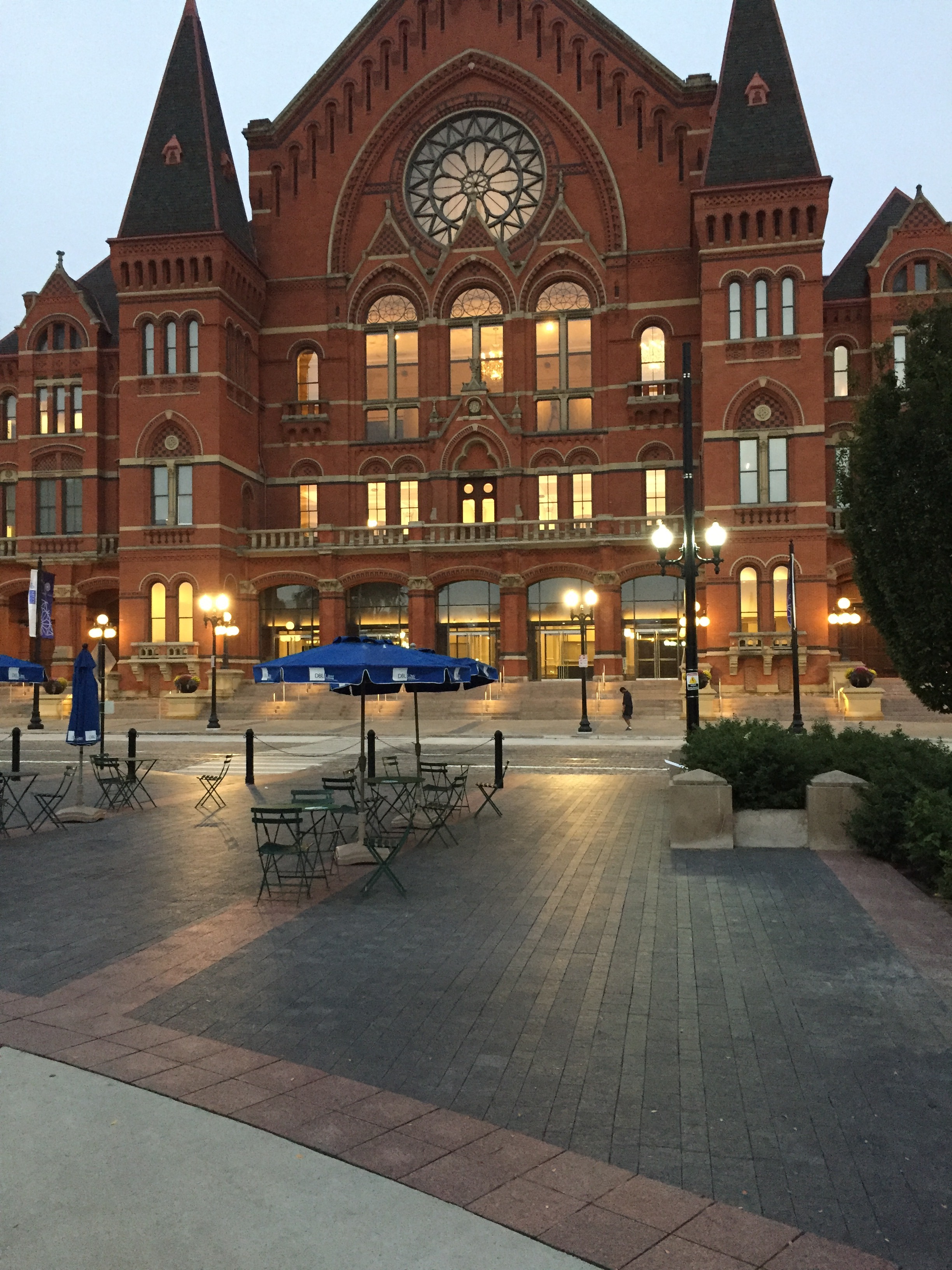 Historic red brick building with large arched windows, evening lighting.