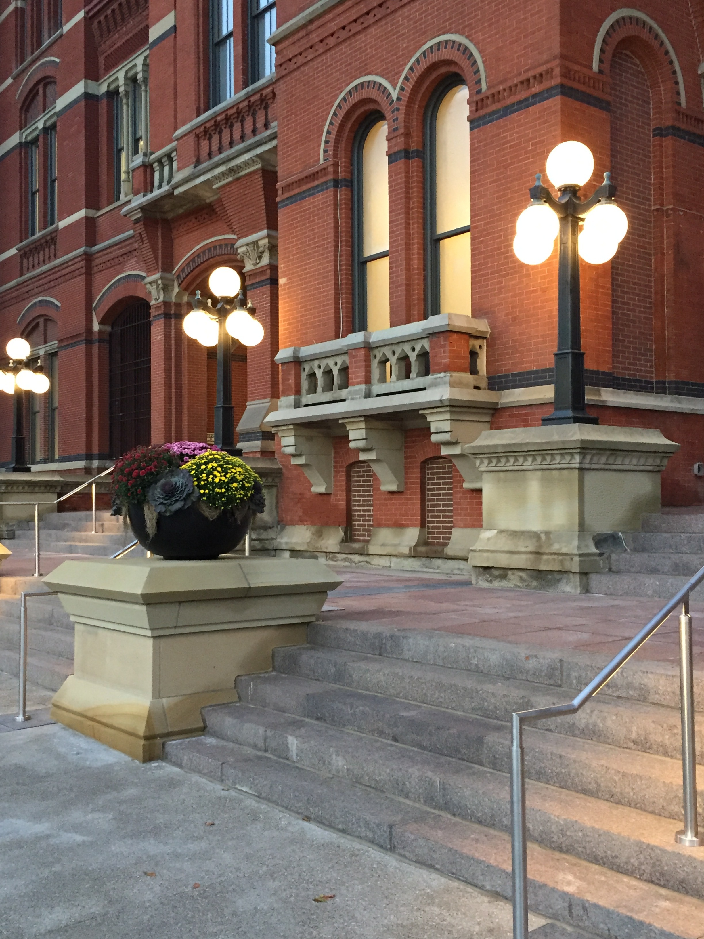 Historic red brick building with lit street lamps and stone steps.