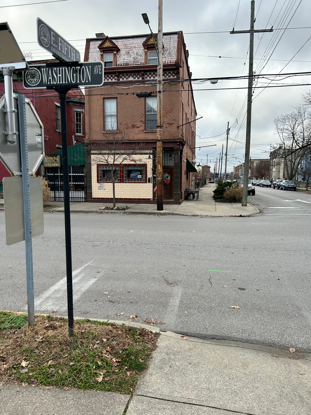 Street corner with a brown brick building and overcast sky.