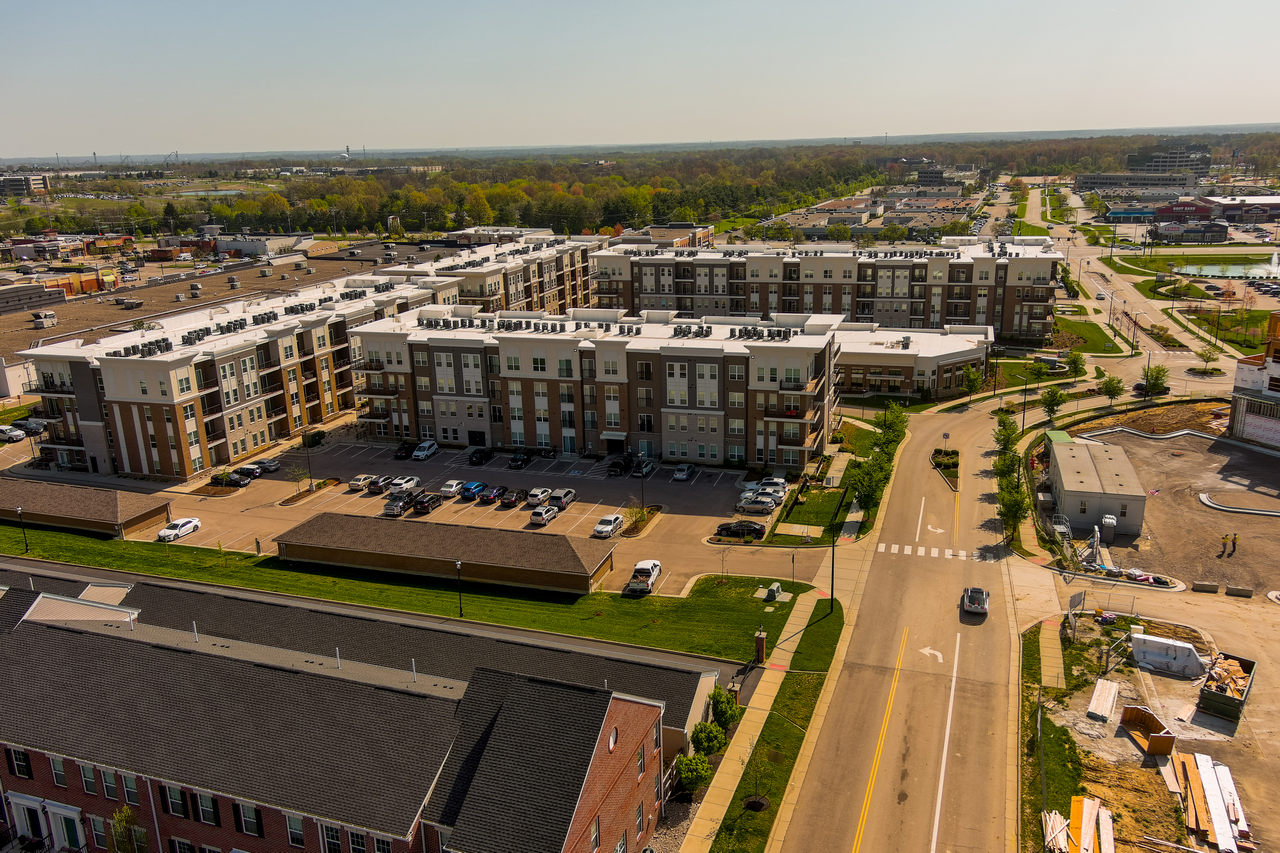 Aerial view of an apartment complex and roads on a sunny day.
