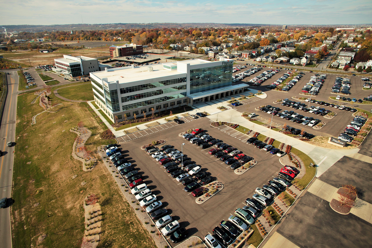 Aerial view of a large building with parking lots and a grassy area.