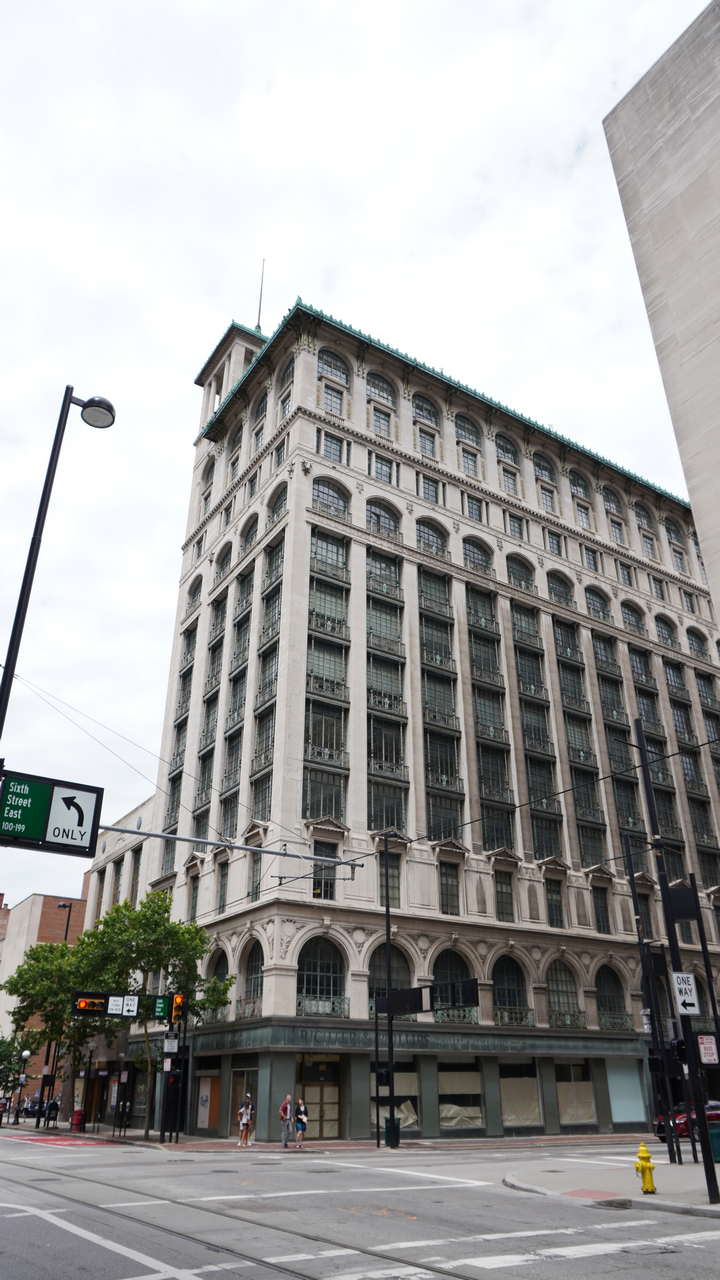 Historic multi-story building on a street corner, overcast sky.