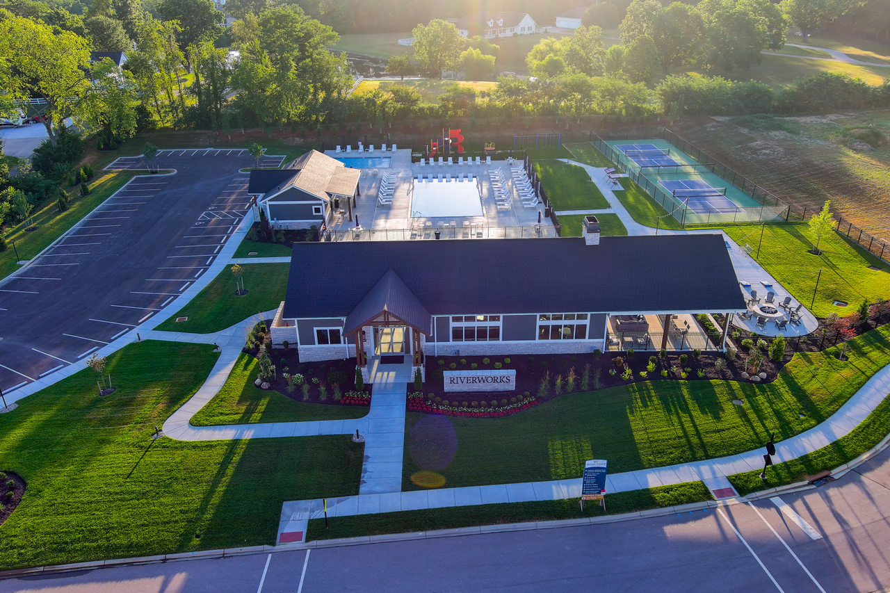 Aerial view of a clubhouse with a pool and surrounding greenery.