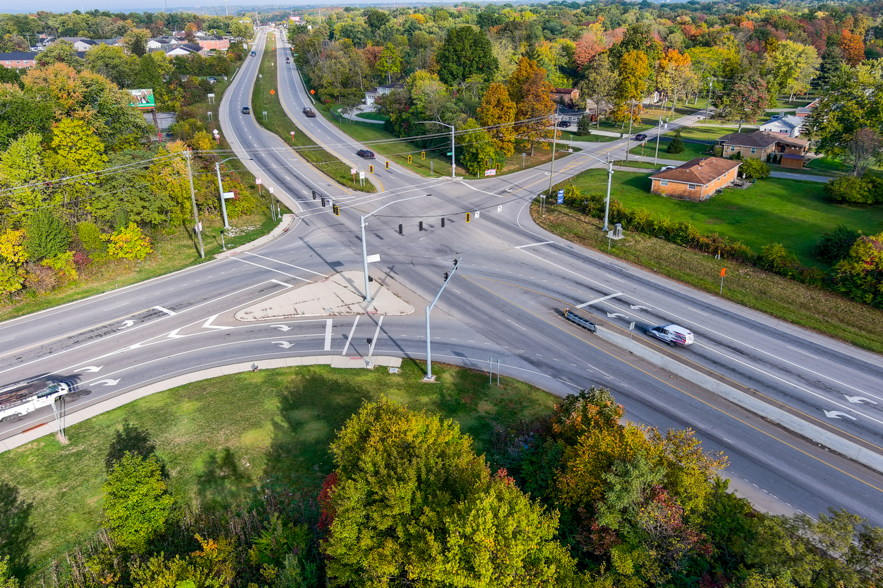 Aerial view of a tree-lined suburban road intersection.