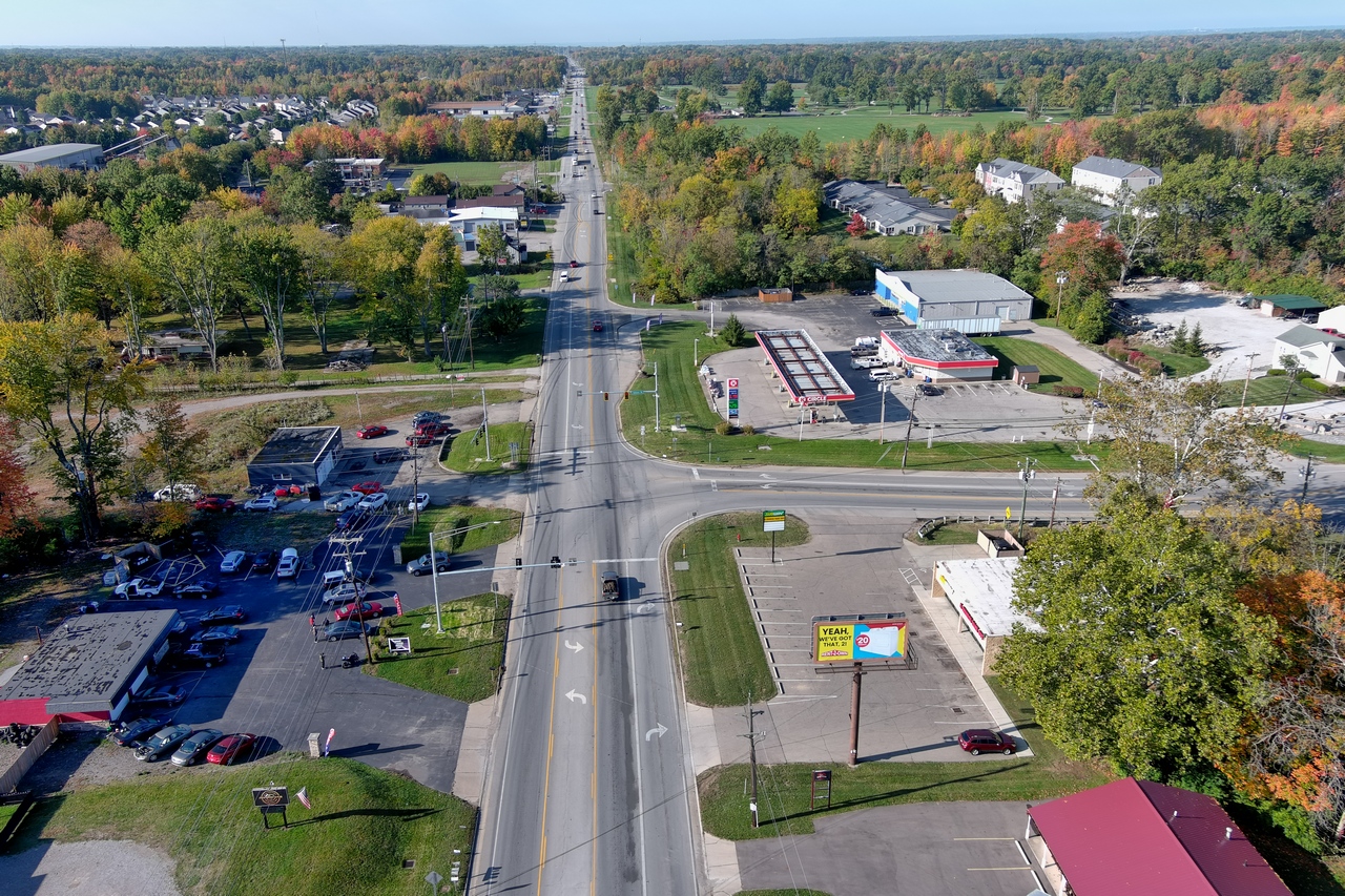 Aerial view of a suburban intersection with trees and buildings.