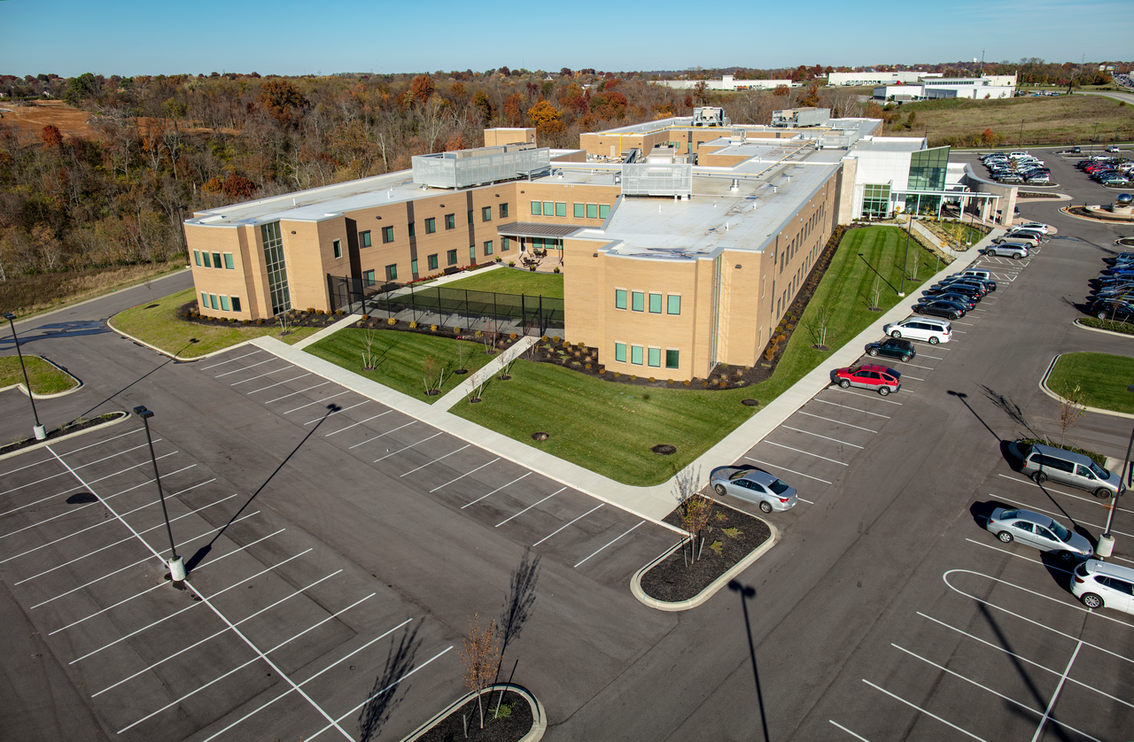 Aerial view of a large, tan building with surrounding parking lot.
