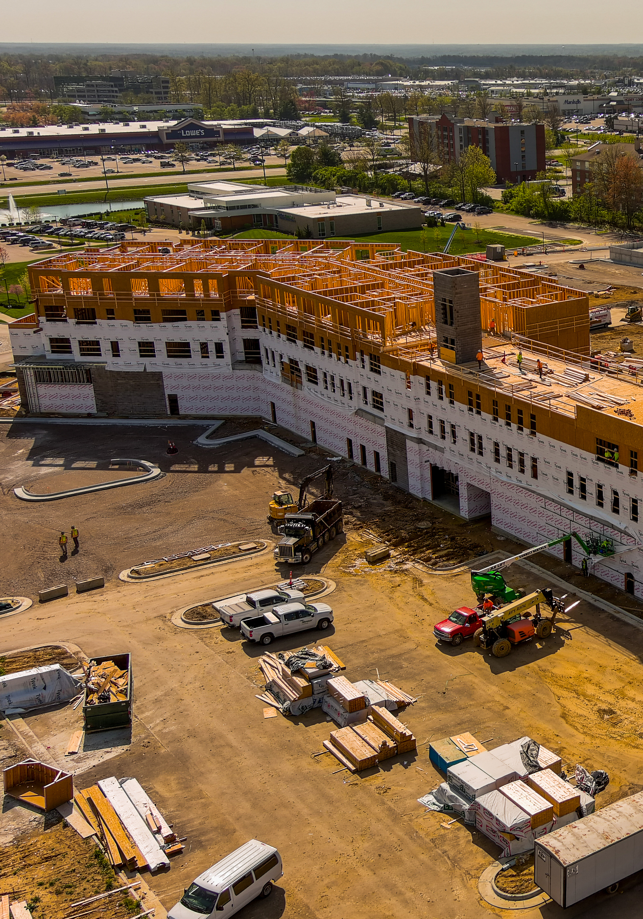 Aerial view of a building under construction, surrounded by vehicles and materials.