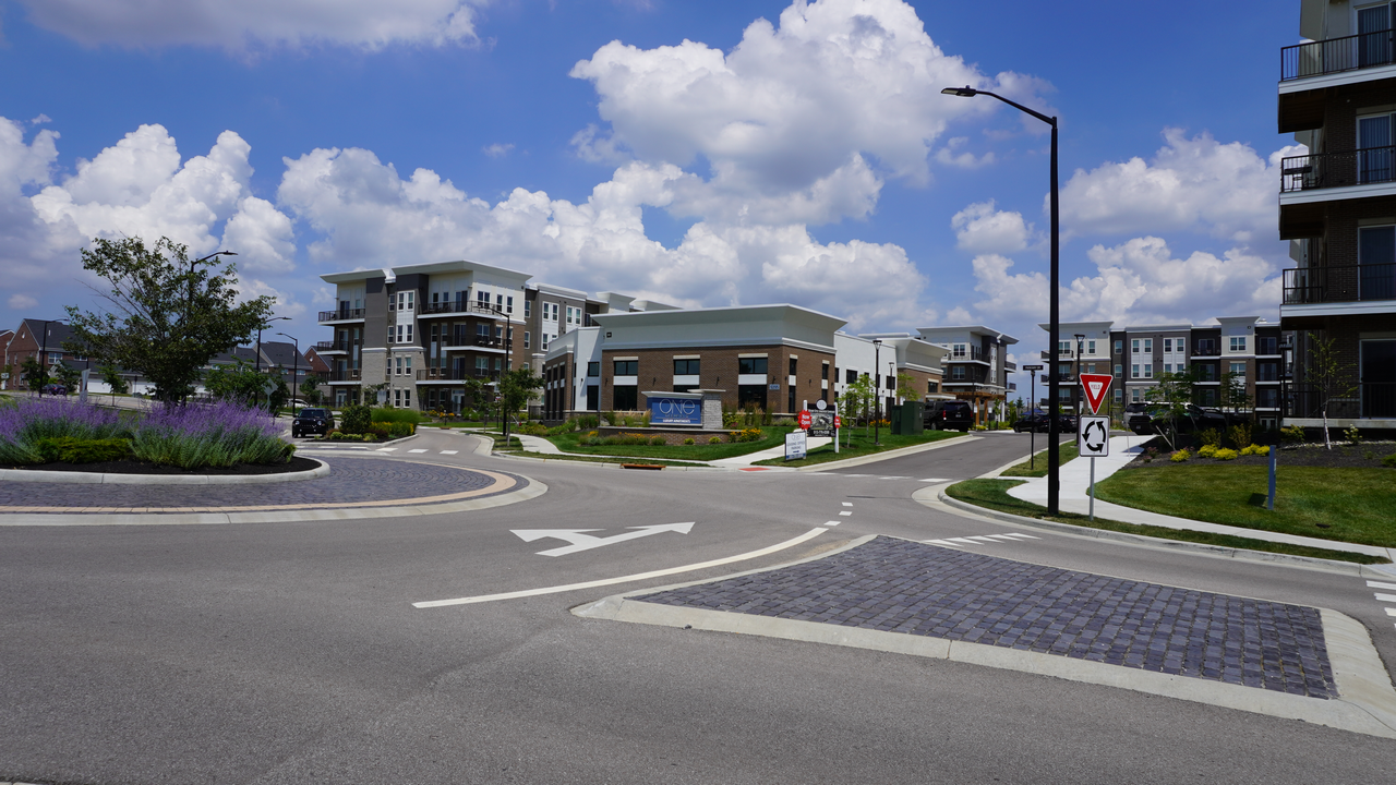 Modern buildings and a street under a cloudy sky.